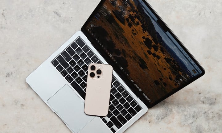 Experimenting with iOS, iPadOS & macOS 26 Beta: My Experience 15 iPhone atop a MacBook Air.