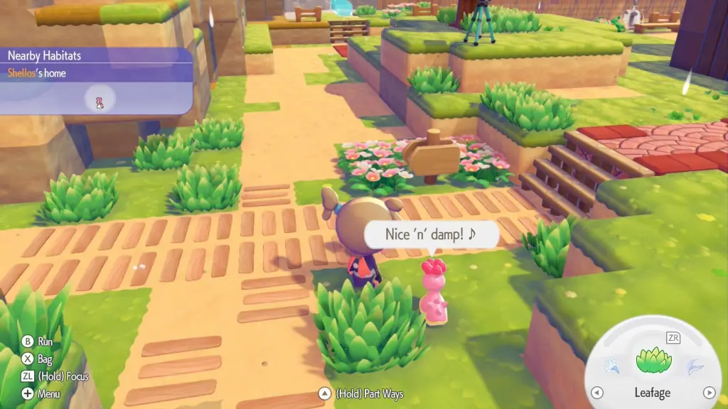 How to Get Shellos in Pokopia: Locations & Tips 7 Shellos expresses how nice and damp its signpost is with a ton of flowers and grass around it.